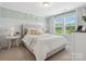 Bedroom featuring a tufted headboard, soft green walls, and a bright window at 301 Supernova Dr, York, SC 29745