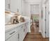Hallway view of a butler's pantry with white cabinets and countertops leading to a dining area at 301 Supernova Dr, York, SC 29745