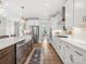 Well-lit kitchen featuring white cabinetry, stainless steel appliances, hardwood floors, and an island at 301 Supernova Dr, York, SC 29745