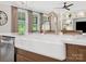 Bright kitchen features a farmhouse sink, gold faucet, stainless steel appliances, and windows offering natural light at 301 Supernova Dr, York, SC 29745
