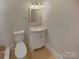 Bright half bathroom with a toilet, vanity with a light-colored countertop, and a mirror at 3109 Morson St, Charlotte, NC 28208