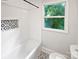 White subway tile bathroom with black and white patterned floor and accent wall at 3109 Morson St, Charlotte, NC 28208