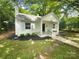 Charming home exterior with a covered porch, light blue shutters, and mature landscaping at 3109 Morson St, Charlotte, NC 28208