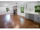 Open living room featuring a brick fireplace, hardwood floors, and bright natural light at 3109 Morson St, Charlotte, NC 28208