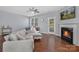 Bright living room with hardwood floors, a fireplace, ceiling fan, and a comfortable gray sectional sofa at 3230 Yarmouth Ln, Gastonia, NC 28056