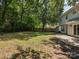 Large backyard with mature trees, a wooden fence, and a concrete patio area, great for entertaining at 3313 Fortis Ln, Matthews, NC 28105