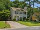 View of the exterior of a two-story home with grey siding, a well-kept lawn, and mature trees around the property at 3313 Fortis Ln, Matthews, NC 28105