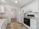 Bright kitchen features white cabinets and appliances, with view to adjacent room at 3313 Fortis Ln, Matthews, NC 28105