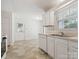 Well-lit kitchen with white appliances and cabinets, with a double sink beneath window at 3313 Fortis Ln, Matthews, NC 28105