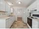 Bright kitchen features white cabinets and appliances, with view to adjacent room at 3313 Fortis Ln, Matthews, NC 28105