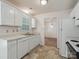 Bright kitchen features white cabinets and appliances, with view to adjacent room at 3313 Fortis Ln, Matthews, NC 28105