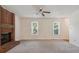 Bright living room featuring a brick fireplace, two windows, neutral walls and carpet, and a ceiling fan at 3313 Fortis Ln, Matthews, NC 28105