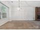 Bright living room featuring neutral carpet, a chandelier, a window, and a brick fireplace at 3313 Fortis Ln, Matthews, NC 28105