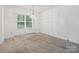 Bright room with neutral carpet, a chandelier light fixture, and a window; neutral paint at 3313 Fortis Ln, Matthews, NC 28105