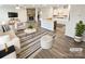 Bright living room and kitchen with stone fireplace, island, and neutral décor in a staged home at 3486 Duchess Ave, Fort Mill, SC 29707