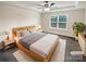 Comfortable main bedroom featuring a tray ceiling, a large window, and modern furnishings at 3486 Duchess Ave, Fort Mill, SC 29707