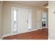 Bright entryway features hardwood floors, a white door with sidelights, and a glimpse into the bedroom at 3523 Brickwood Cir, Midland, NC 28107
