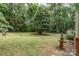 Expansive backyard featuring a lush green lawn, mature trees, and a charming decorative fountain at 3884 Snider Cir, Hickory, NC 28602