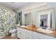 Bathroom featuring a double sink vanity with ample storage, decorative mirrors, and a shower with a leaf-patterned curtain at 3884 Snider Cir, Hickory, NC 28602