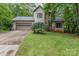 Charming home featuring a two-car garage, stone accents, mature landscaping, and a cozy covered porch at 3884 Snider Cir, Hickory, NC 28602