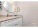 Bathroom vanity with granite countertop, white cabinets, and decorative mirror at 3965 Hemingway Dr, Hickory, NC 28601