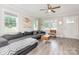 Bright living room with large windows, ceiling fan, and stylish furnishings, including a large sectional sofa at 3965 Hemingway Dr, Hickory, NC 28601
