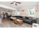 Open-concept living room with a gray sectional sofa, wood flooring, and views of the adjacent kitchen at 3965 Hemingway Dr, Hickory, NC 28601