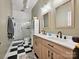 Modern bathroom featuring double sinks, walk-in shower, and checkerboard flooring at 404 N Laurel Ave # 11, Charlotte, NC 28204