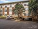 Condo exterior with covered parking and mature landscaping at 404 N Laurel Ave # 11, Charlotte, NC 28204