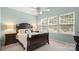 Inviting bedroom with a wooden bed frame, three sunlit windows, and bedside lamps at 424 Paperbark Ln, Rock Hill, SC 29732