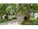 Home exterior with white garage door, mature trees, and a well-manicured lawn at 424 Paperbark Ln, Rock Hill, SC 29732