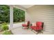 Relaxing covered patio features comfortable chairs with pillows and beautiful greenery at 424 Paperbark Ln, Rock Hill, SC 29732