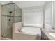 Bright bathroom featuring a soaking tub under a window and a glass enclosed shower with tiled walls at 481 Evergreen Rd, Clover, SC 29710