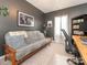 Cozy bedroom featuring a gray futon sofa, modern artwork, a large window, and a built-in bookshelf at 5432 Kinsbridge Dr, Charlotte, NC 28227