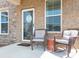 Cozy front porch features comfortable seating and classic brick accents at 5432 Kinsbridge Dr, Charlotte, NC 28227