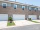 Exterior of a three-car garage with white doors, brick facade, and well-maintained landscaping at 5432 Kinsbridge Dr, Charlotte, NC 28227