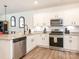 Bright kitchen features stainless steel appliances, granite countertops, and white cabinets at 5432 Kinsbridge Dr, Charlotte, NC 28227