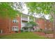 Exterior view of a brick condo building featuring balconies with white railings, windows and a grassy area at 5601 Fairview Rd # 11, Charlotte, NC 28209