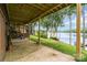Covered back porch offers scenic views of the lush lawn extending to the lake at 6719 Love Point Rd, Denver, NC 28037