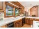 Kitchen with wood cabinetry, tiled countertops, a window view, and access to living spaces at 6719 Love Point Rd, Denver, NC 28037