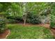 Tranquil backyard featuring lush greenery, mature trees, and landscaping that enhances the outdoor serenity at 7101 Weavers Run, Cramerton, NC 28032