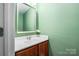 A half bathroom with an updated vanity, framed mirror, and neutral color scheme at 7101 Weavers Run, Cramerton, NC 28032