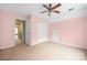 Cozy bedroom with pink walls, ceiling fan, carpet, and double-door closet at 7101 Weavers Run, Cramerton, NC 28032