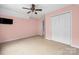 Carpeted bedroom with pink walls, closet, and ceiling fan at 7101 Weavers Run, Cramerton, NC 28032