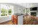 Open concept living space featuring a kitchen island, wood floors, and natural light at 7101 Weavers Run, Cramerton, NC 28032