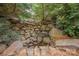 Backyard landscaping with rocks, and plantings creating a serene ambiance and a natural rock waterfall feature at 7101 Weavers Run, Cramerton, NC 28032