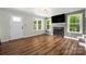 Inviting living room with a fireplace, wood floors, and abundant natural light from large windows at 7101 Weavers Run, Cramerton, NC 28032