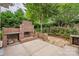 A brick fireplace, seating, and lush greenery enhance this patio, creating a relaxing outdoor living space at 7101 Weavers Run, Cramerton, NC 28032