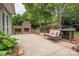 Relaxing patio featuring an outdoor fireplace, comfortable bench seating, and views of lush greenery at 7101 Weavers Run, Cramerton, NC 28032
