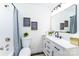 Nicely decorated bathroom featuring neutral wall art, framed mirror, white vanity, and a shower tub at 810 W Raleigh Ave, Statesville, NC 28677